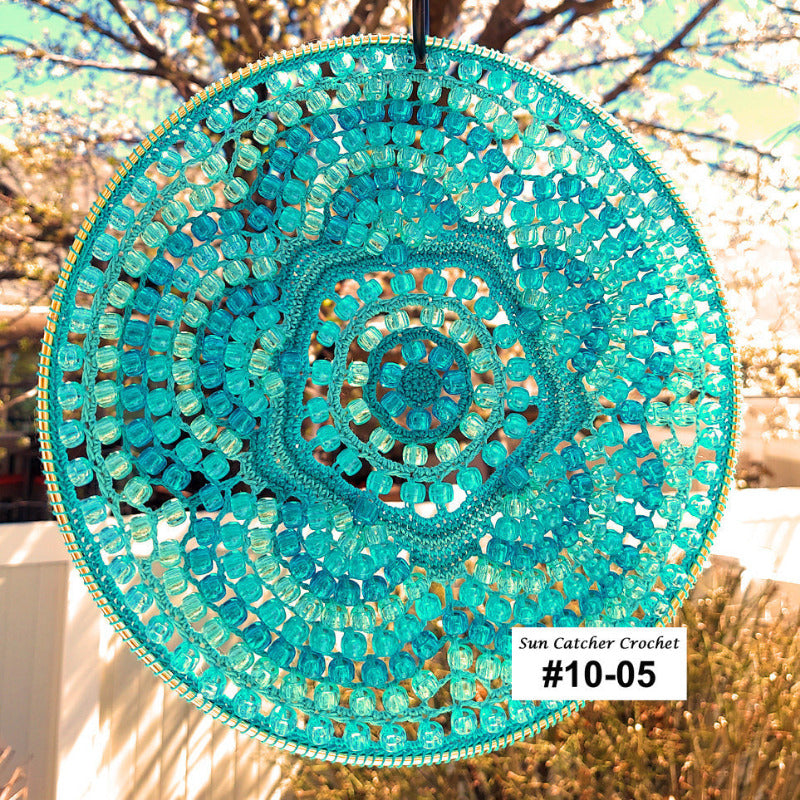 Turquoise beaded sun catcher with a blurred natural background