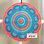 Decorative circular sun catcher with blue and pink colors on a white background