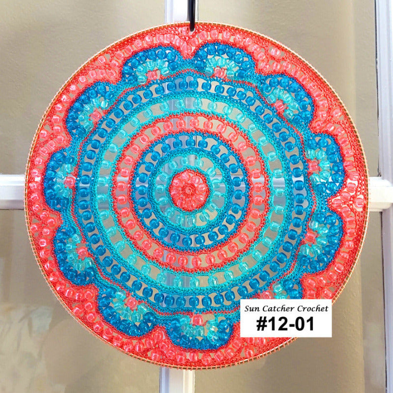 Decorative circular sun catcher with blue and pink colors on a white background