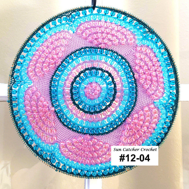 Circular sun catcher with blue and pink spiral pattern on a white background