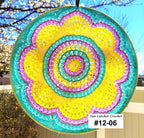 Colorful sun catcher with a spiral pattern against a blurred outdoor background