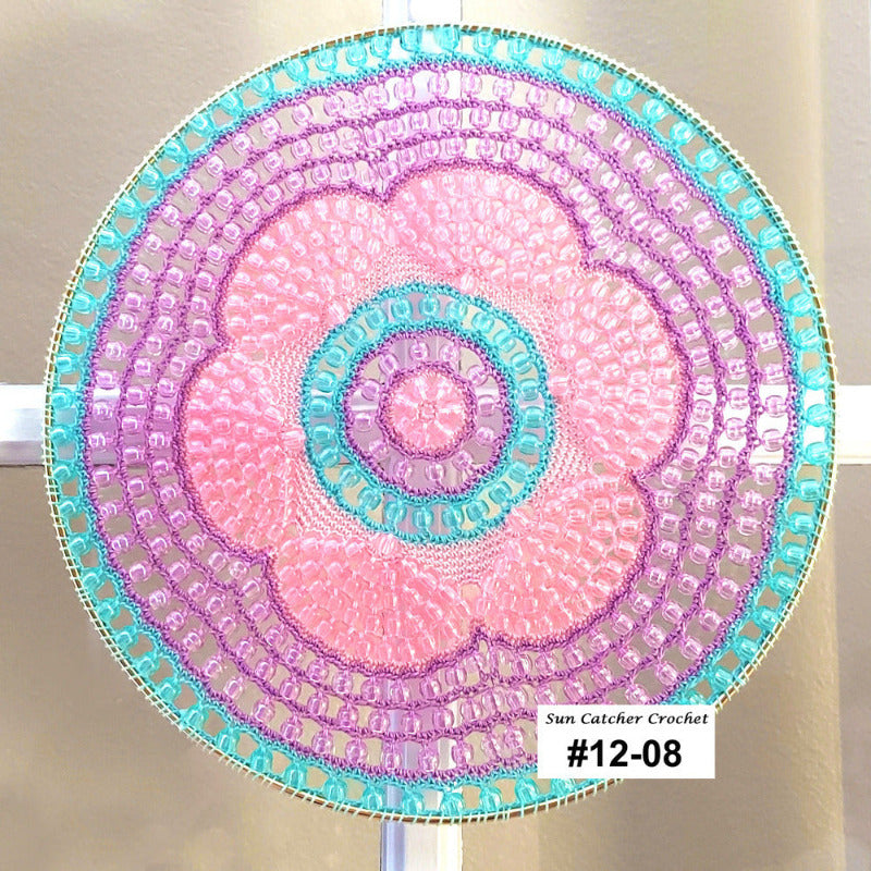 Decorative sun catcher with a spiral pattern in pink and blue on a white background