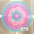 Decorative sun catcher with a spiral pattern in pink and blue on a white background