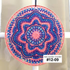 Decorative circular sun catcher with pink and blue patterns on a white background