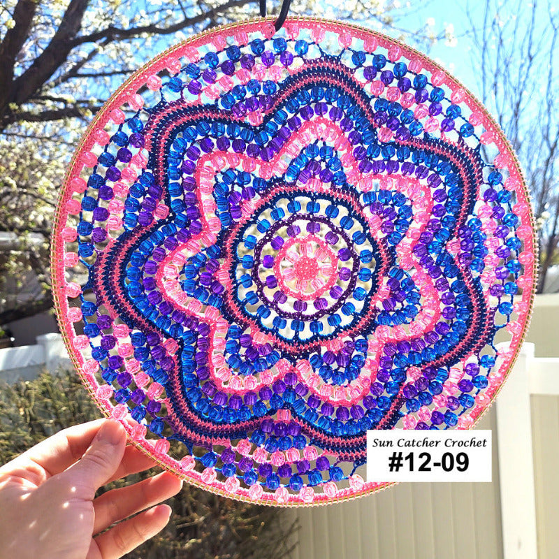 Colorful beaded circular craft held by a hand with a blurred outdoor background