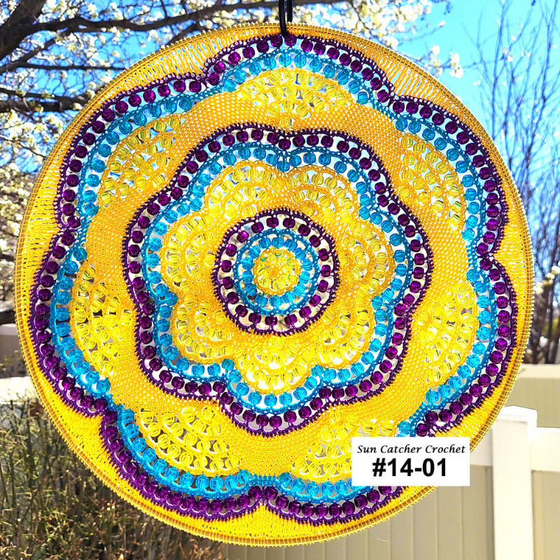 Decorative sun catcher with spiral pattern in yellow, blue, and purple hanging outdoors.