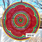 Colorful circular crochet sun catcher with a blurred outdoor background