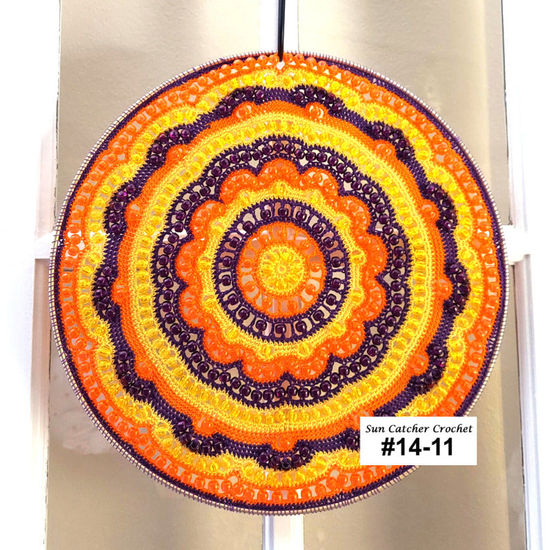 Colorful crocheted sun catcher with concentric circles on a white background