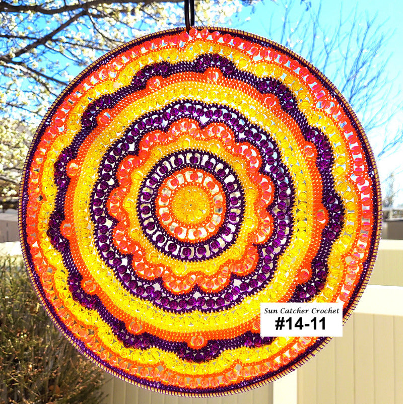 Colorful circular sun catcher with concentric patterns against a natural background