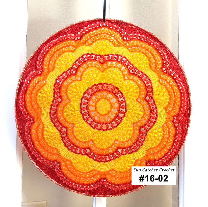 Round crochet sun catcher with a gradient of red to yellow on a white background