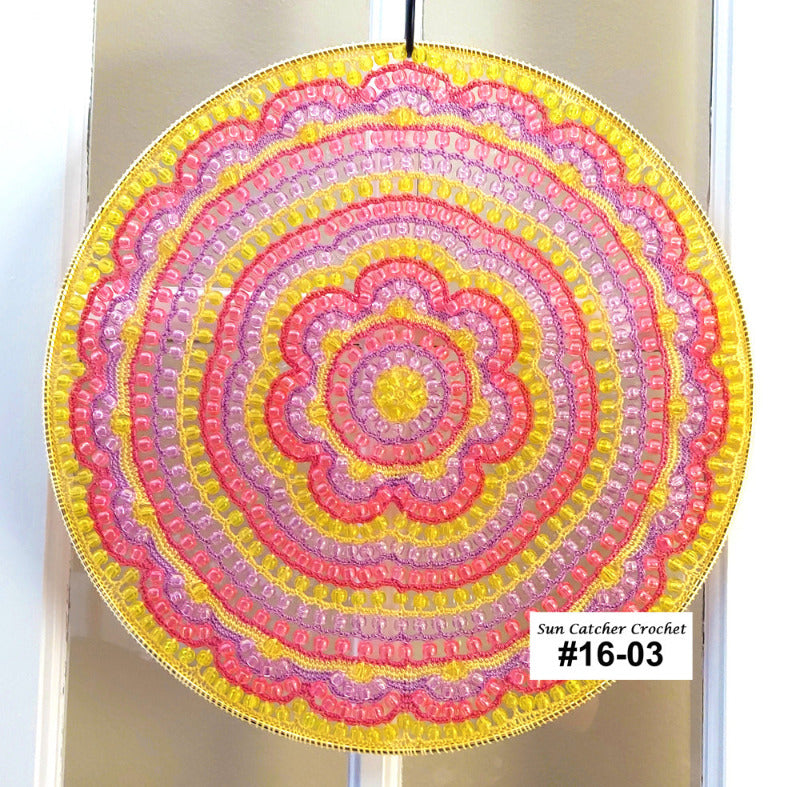 Sun catcher crochet with pink and yellow colors on a clear background