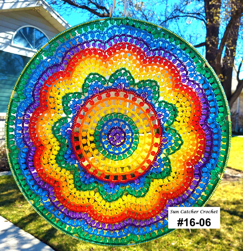 Colorful circular sun catcher with a house and tree in the background