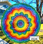 Colorful circular sun catcher with a house and tree in the background