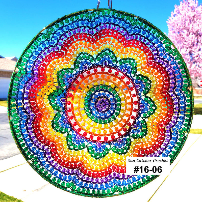 Colorful beaded sun catcher with a rainbow pattern against a blue sky.
