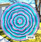 Colorful circular crochet design in a garden setting