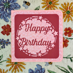 Pink 'Happy Birthday' card with star decorations on a floral background