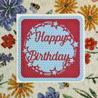 Red card with 'Happy Birthday' text on a floral-patterned background