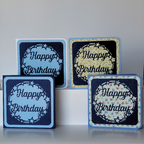 Four 'Happy Birthday' greeting cards with decorative patterns on a white surface.