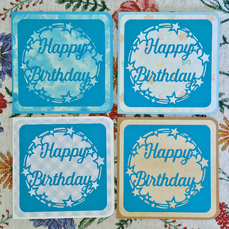 Four blue 'Happy Birthday' cards on a floral background