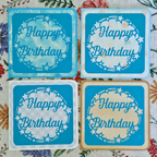 Four blue 'Happy Birthday' cards on a floral background
