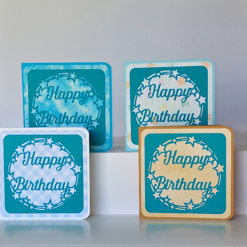 Four 'Happy Birthday' cards with decorative text on a white surface