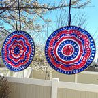 Two circular decorative items with red, white, and blue patterns hanging outdoors against a clear sky.