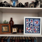 Shelf with vintage cameras, decorative bottles, clocks, and a framed 'HOME' sign.
