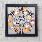 Framed Halloween-themed artwork with text and icons on a white brick wall background