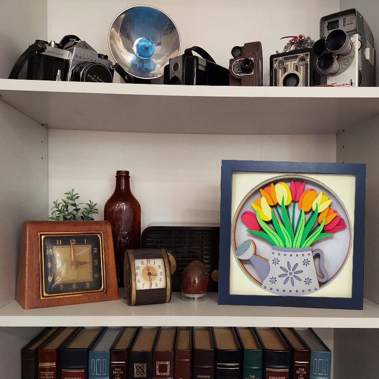Shelf with vintage cameras, decorative items, and a framed picture of flowers.