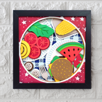 Framed artwork of food items on a plate with a red background