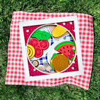 Colorful toy food set on a red and white checkered blanket on grass