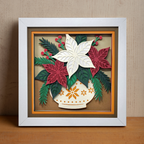 Framed paper art of poinsettias and leaves on a wooden surface with a beige wall background