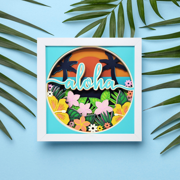 Framed artwork with 'aloha' text and tropical elements on a blue background with palm leaves.