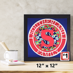 Framed artwork with floral design and letter 'S' on a blue background, placed on a desk.