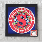 Decorative wall art with a red 'S' and floral patterns on a blue background, framed in black.