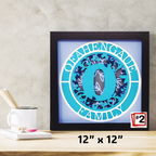 Framed decorative letter 'O' with a blue and purple design on a wooden surface.
