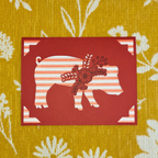 Red card with bear silhouette and floral design on a yellow floral-patterned background