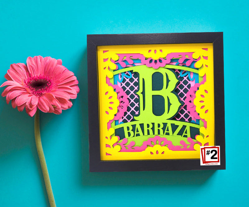 Decorative wall art with a colorful letter 'B' and text on a blue background, accompanied by a pink flower.