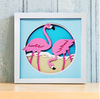 Framed artwork with pink flamingo cutouts on a blue background