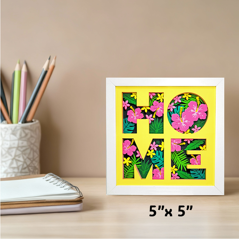 Framed decorative sign with 'HOME' letters on a desk with stationery items.