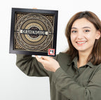 Woman holding a framed decorative wall art with 'Ofahengaue' text on a white background
