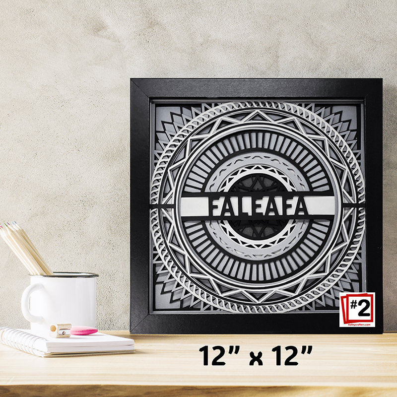 Decorative wall art with 'FALEAFA' design on a wooden surface with a mug and stationery items.