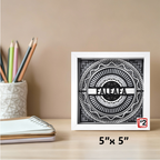 Framed black and white artwork with 'FALEAFA' on a desk with stationery items.