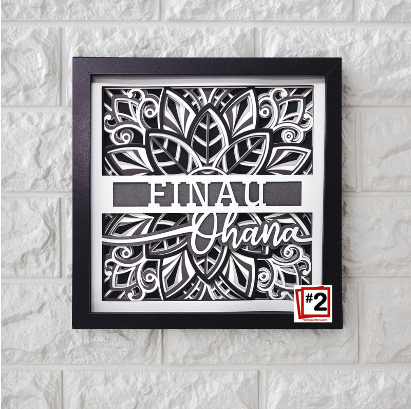 Framed black and white artwork with text on a textured wall