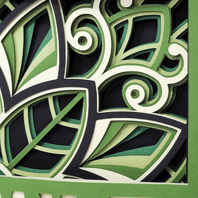 Close-up of a decorative design with green, black, and white colors on a black background.