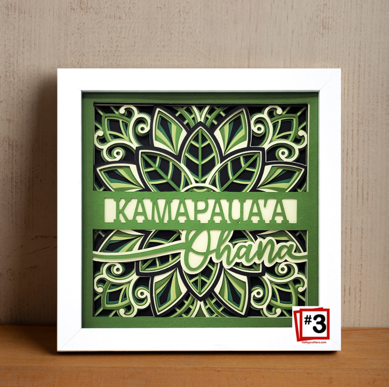 Decorative wall art with green and white design on a wooden surface