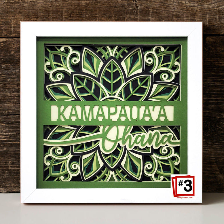 Decorative wall art with green leaf patterns and text on a wooden background
