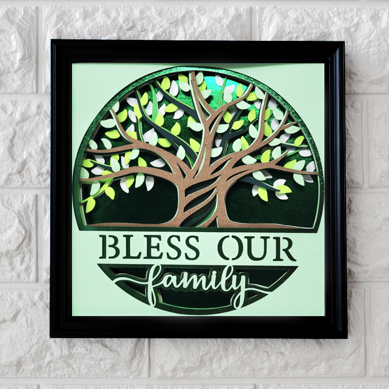 Framed artwork with a tree design and 'Bless our family' text on a light green background.