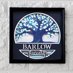 Framed artwork with a blue tree design and 'Barlow Family' text on a textured wall.