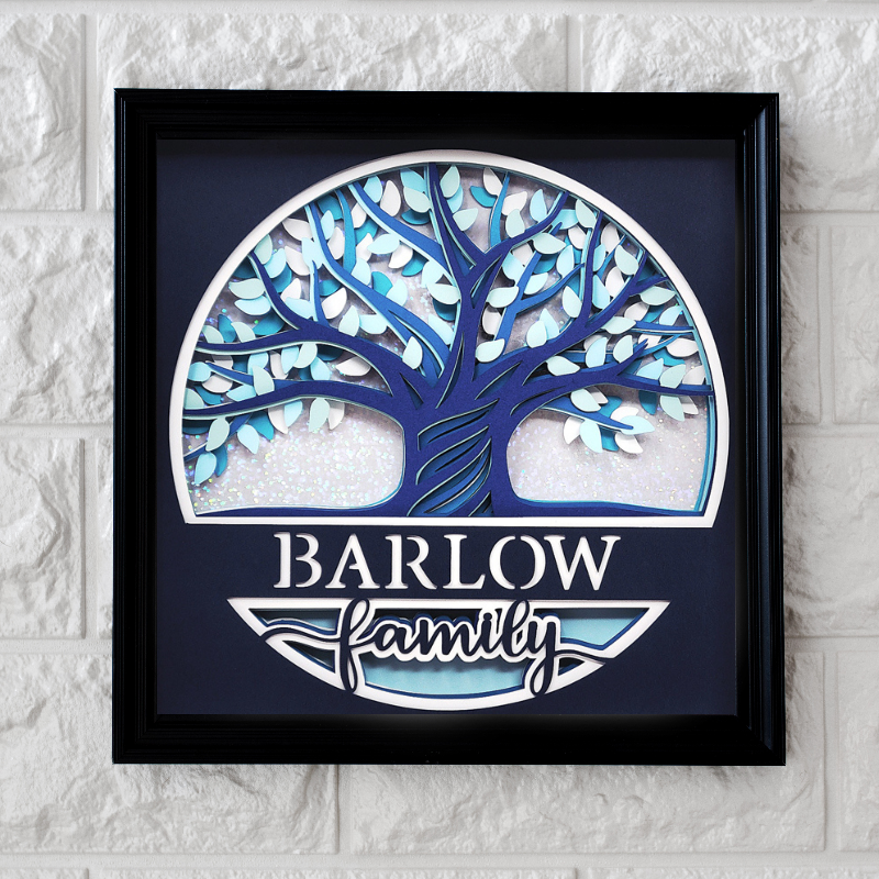 Framed artwork with a blue tree design and 'Barlow Family' text on a textured wall.